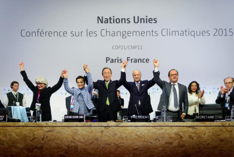 Policy makers hold hands in celebration at the signing of the Paris Agreement